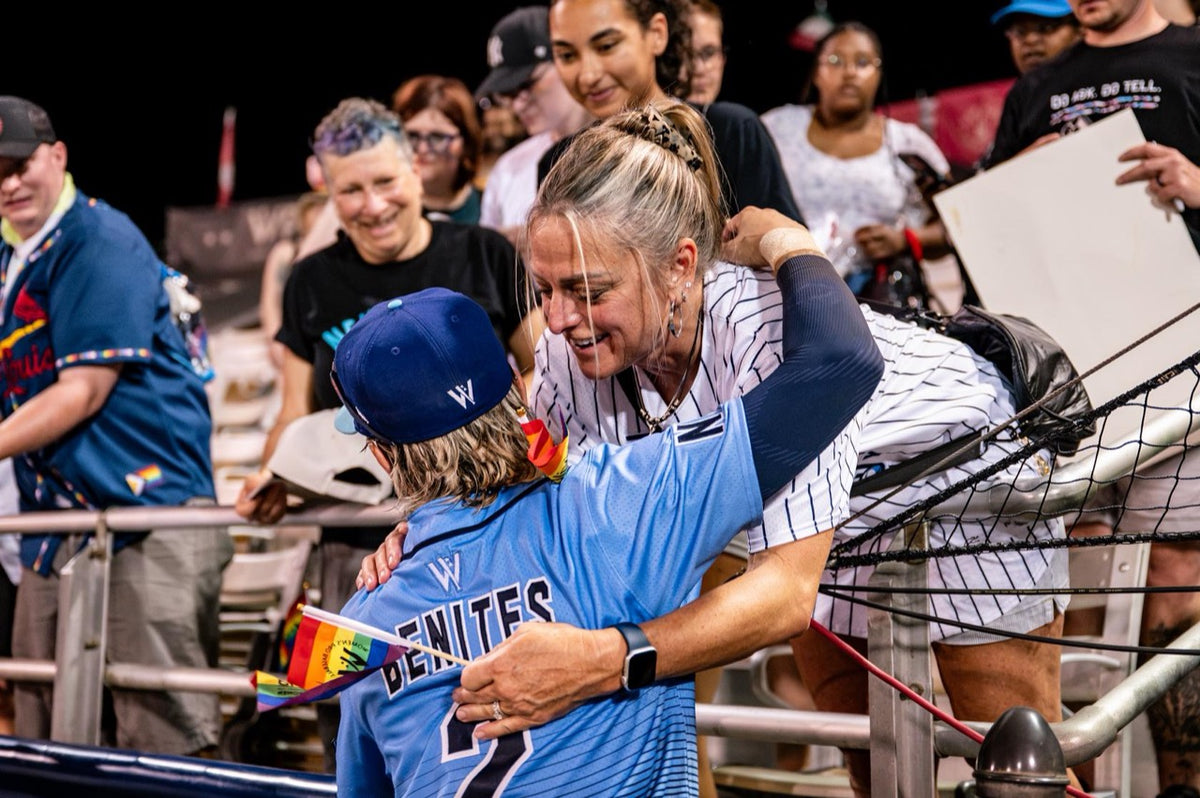 A WPBL player and a fan embrace across the stadium railing.